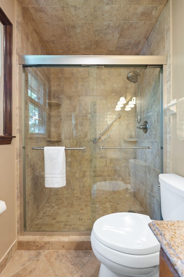 bathroom with vanity, a stall shower, and toilet