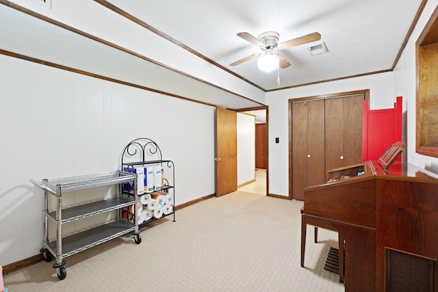interior space featuring visible vents, crown molding, baseboards, ceiling fan, and carpet