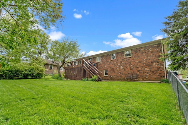 back of house featuring stairway, brick siding, a fenced backyard, and a deck