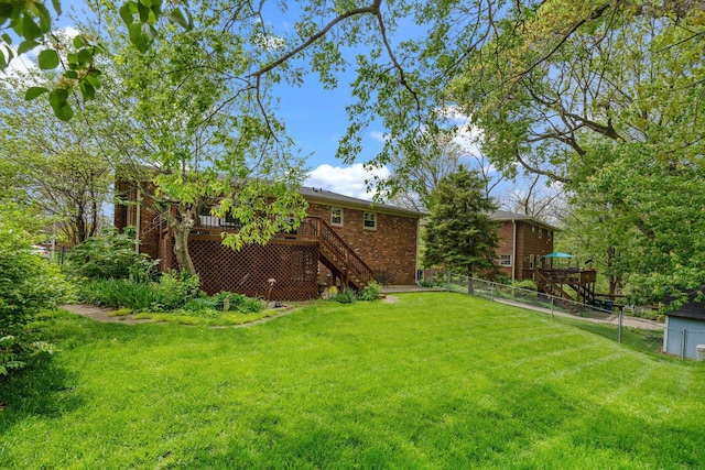 view of yard with fence, a deck, and stairway