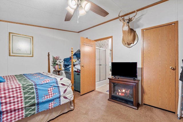 carpeted bedroom featuring crown molding and a ceiling fan