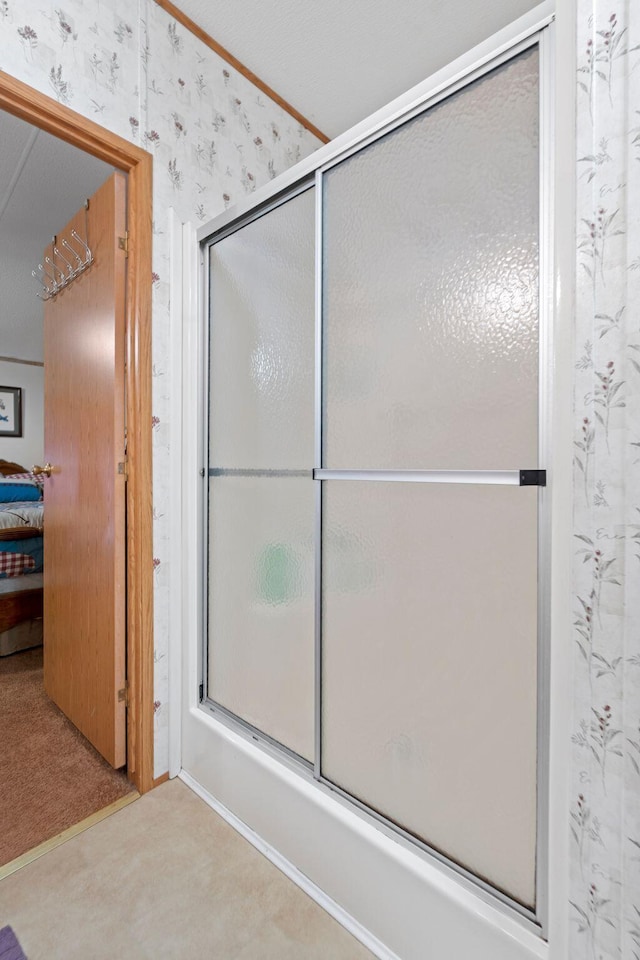 ensuite bathroom with shower / bath combination with glass door, ensuite bathroom, and wallpapered walls