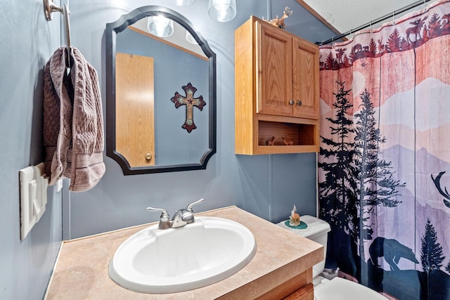 bathroom featuring toilet, curtained shower, and vanity
