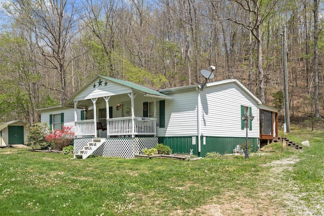 view of front facade with a storage shed, a porch, a front lawn, and an outdoor structure