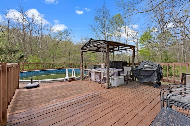 wooden deck with a gazebo, an outdoor pool, a jacuzzi, and a grill