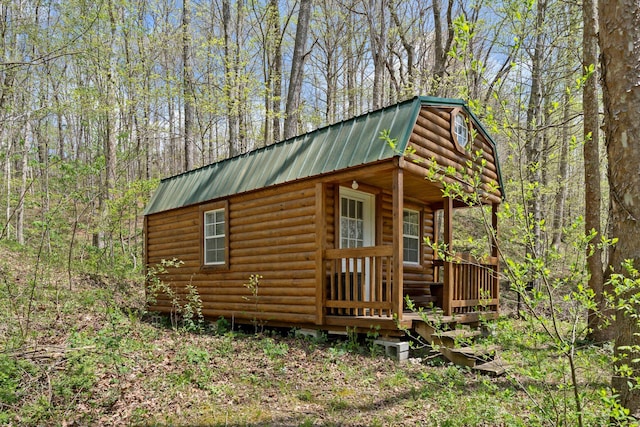 exterior space with a wooded view and an outbuilding