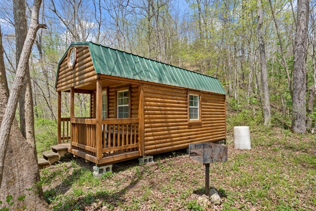 view of outdoor structure with a wooded view and an outdoor structure