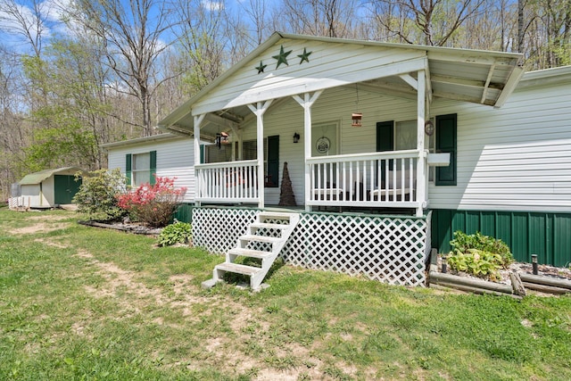 view of front of house with covered porch, a front lawn, an outbuilding, and a storage shed