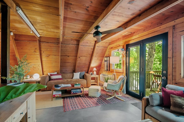 living area featuring beam ceiling, wood walls, ceiling fan, and wooden ceiling