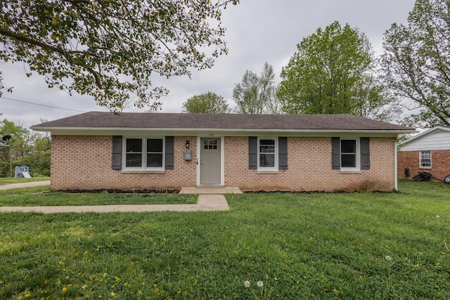 ranch-style house with brick siding, a front yard, and roof with shingles