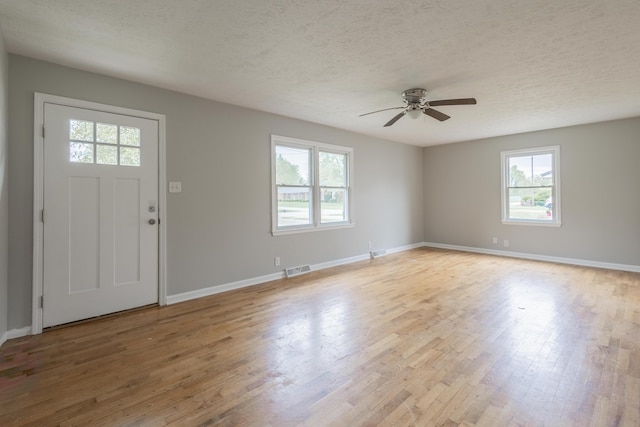 entryway with light wood-type flooring, a ceiling fan, and plenty of natural light