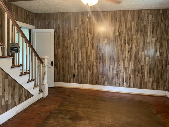 346 Slate Ave, Owingsville, KY 40360 - empty room with a textured ceiling, wood walls, stairway, ceiling fan, and wood-type flooring