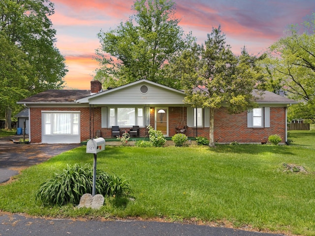 507 Holman Dr, Stanton, KY 40380 - ranch-style house with a porch, brick siding, a front yard, a chimney, and driveway