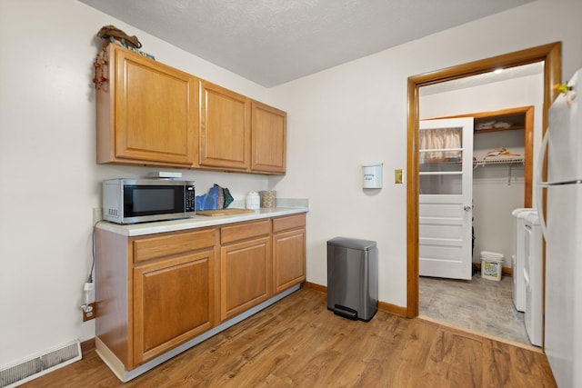 507 Holman Dr, Stanton, KY 40380 - kitchen featuring stainless steel microwave, light wood-style floors, freestanding refrigerator, and light countertops