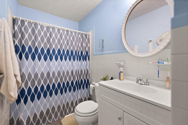 507 Holman Dr, Stanton, KY 40380 - bathroom featuring toilet, vanity, tile walls, curtained shower, and a textured ceiling