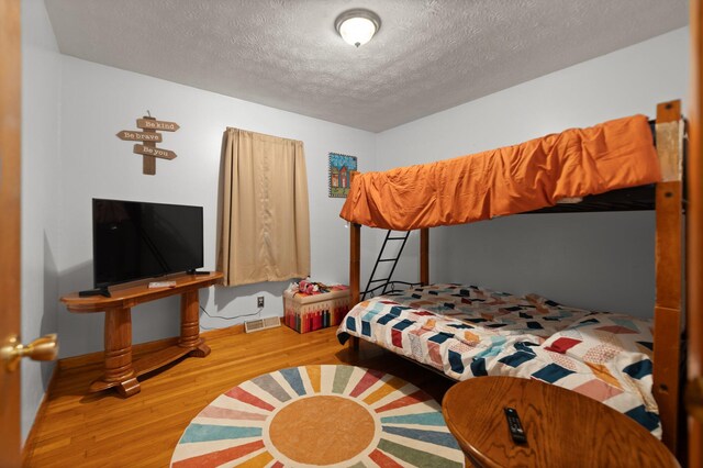 507 Holman Dr, Stanton, KY 40380 - bedroom with wood finished floors, a textured ceiling, and baseboards