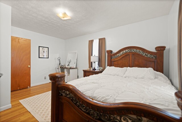 507 Holman Dr, Stanton, KY 40380 - bedroom with light wood-style floors, a textured ceiling, and baseboards