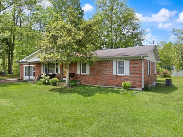 507 Holman Dr, Stanton, KY 40380 - ranch-style house featuring brick siding, covered porch, a front yard, and central AC