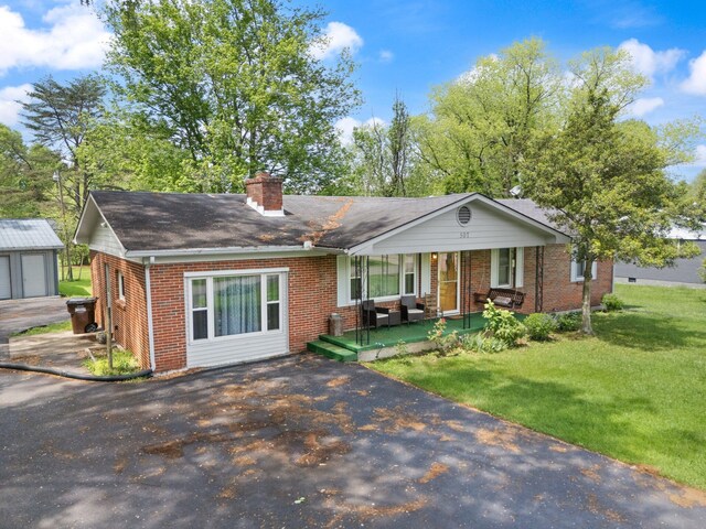 507 Holman Dr, Stanton, KY 40380 - ranch-style home featuring brick siding, a chimney, a front yard, a porch, and a shingled roof