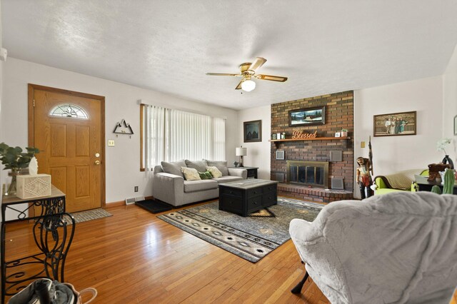 507 Holman Dr, Stanton, KY 40380 - living area with ceiling fan, a fireplace, wood-type flooring, and healthy amount of natural light
