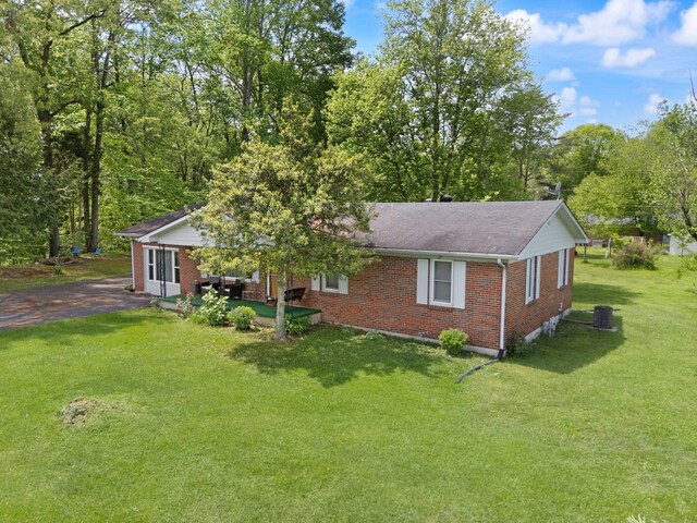 507 Holman Dr, Stanton, KY 40380 - single story home featuring brick siding, a front yard, asphalt driveway, roof with shingles, and a patio