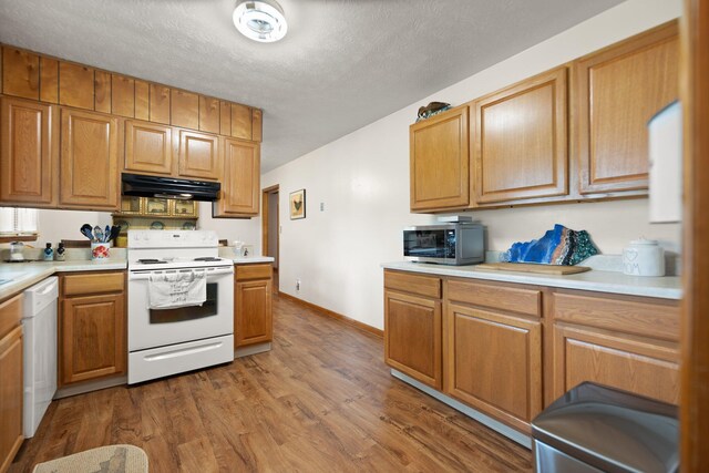 507 Holman Dr, Stanton, KY 40380 - kitchen featuring white appliances, under cabinet range hood, wood finished floors, light countertops, and a textured ceiling