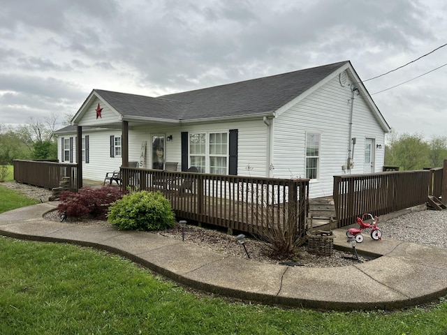 view of front of house featuring a deck and a shingled roof