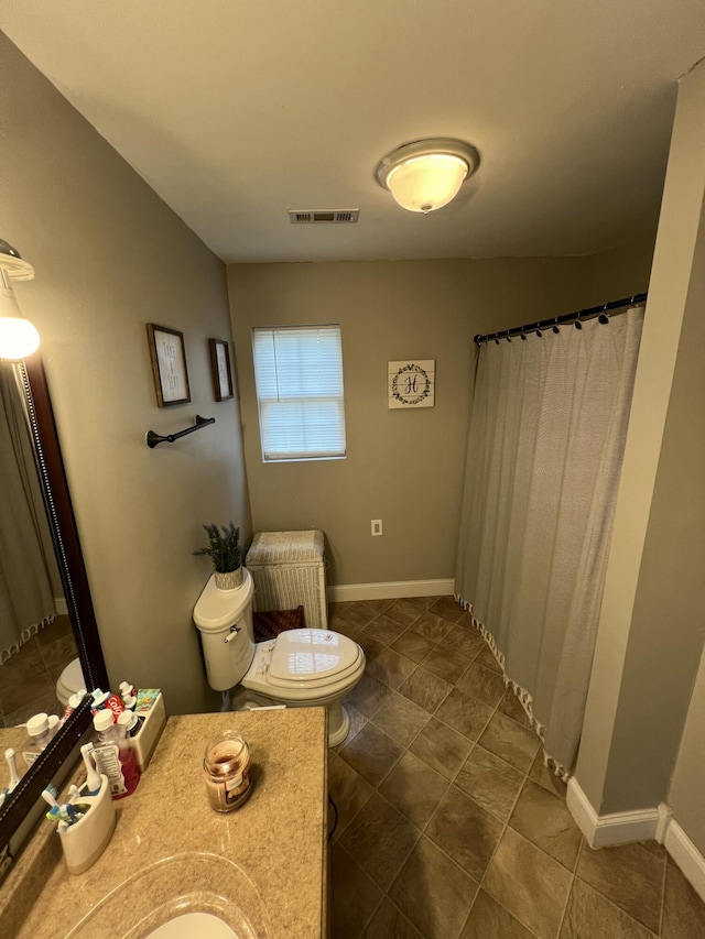 bathroom with vanity, toilet, visible vents, baseboards, and tile patterned flooring