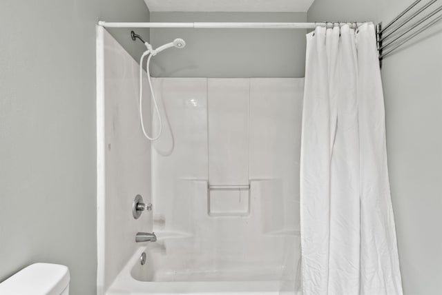 bathroom with toilet and shower / bath combo