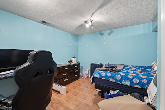bedroom with visible vents and a textured ceiling