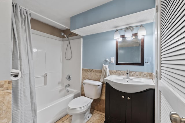 bathroom featuring shower / bath combination with curtain, tile walls, wainscoting, vanity, and toilet