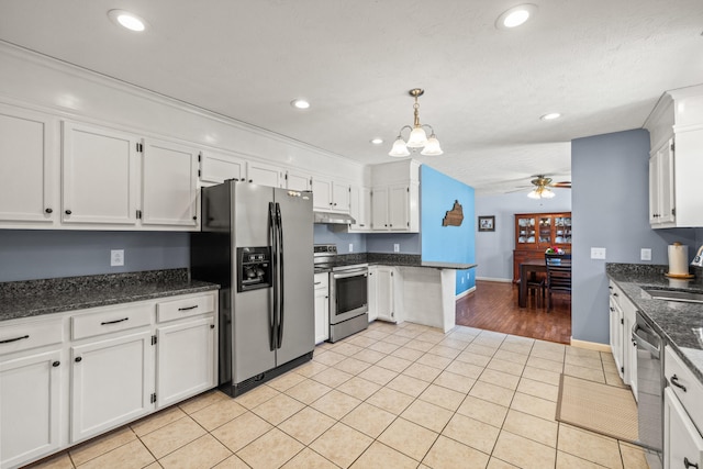 kitchen with white cabinets, stainless steel appliances, a sink, and ceiling fan with notable chandelier
