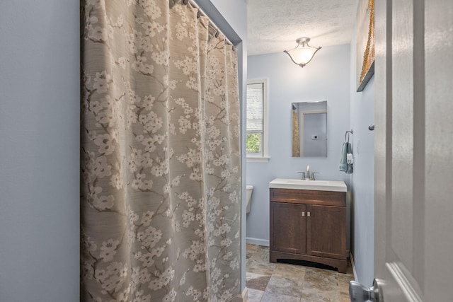 bathroom featuring vanity, a textured ceiling, toilet, and curtained shower