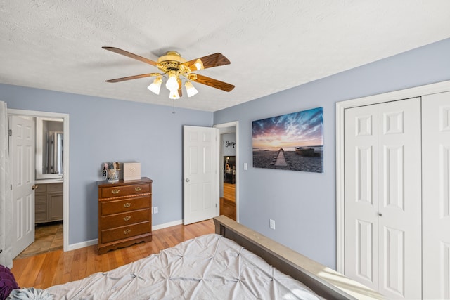 bedroom with baseboards, ceiling fan, a closet, and wood finished floors