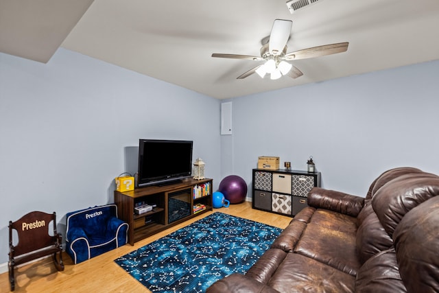 living area featuring baseboards, a ceiling fan, wood finished floors, and visible vents