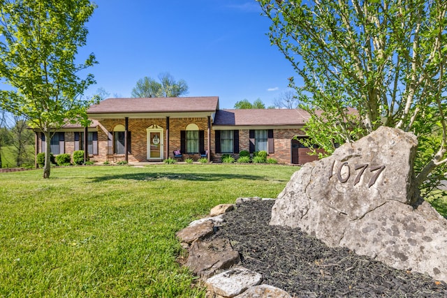 ranch-style home with an attached garage, brick siding, driveway, and a front yard