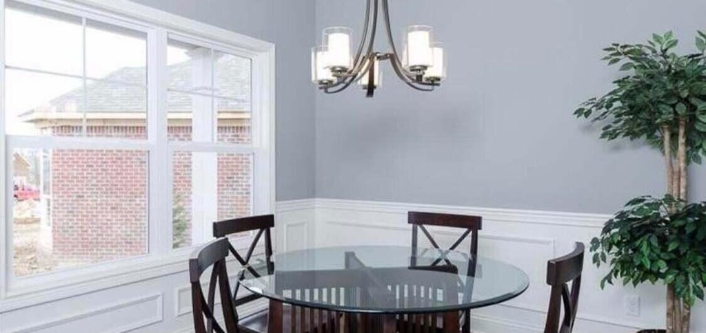 dining area featuring an inviting chandelier, a decorative wall, and wainscoting
