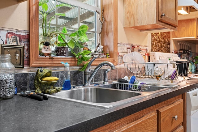 1142 Indian Creek Rd, Sadieville, KY 40370 - kitchen with brown cabinets, white dishwasher, dark countertops, a sink, and a wealth of natural light
