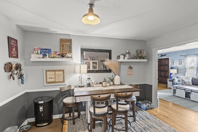 dining room featuring wood finished floors and bar