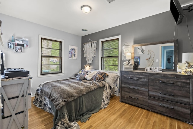 bedroom featuring multiple windows and light wood-style floors