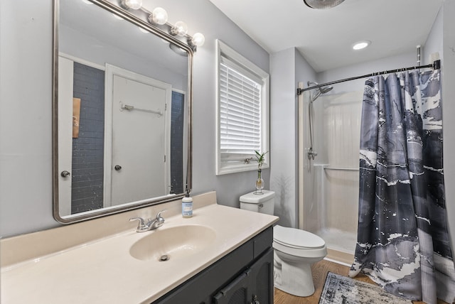 bathroom with curtained shower, wood finished floors, toilet, and vanity