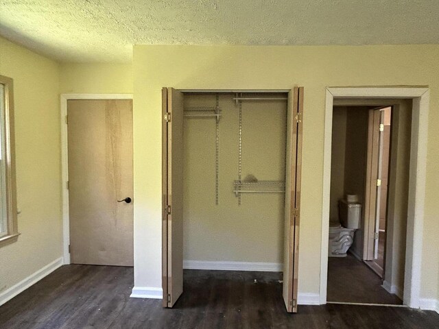 unfurnished bedroom featuring a closet, baseboards, wood finished floors, and a textured ceiling