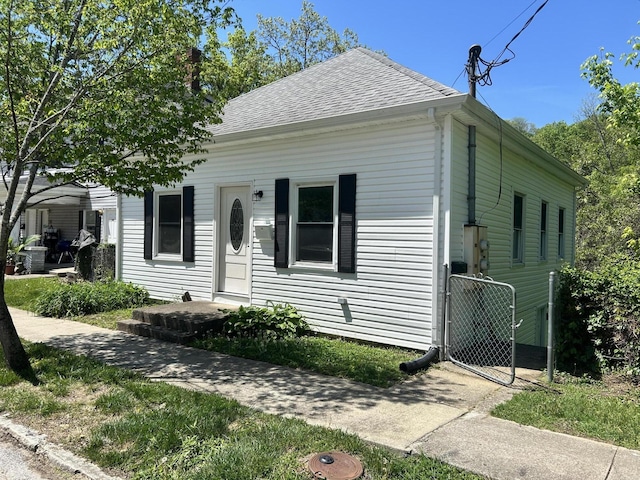 bungalow featuring roof with shingles