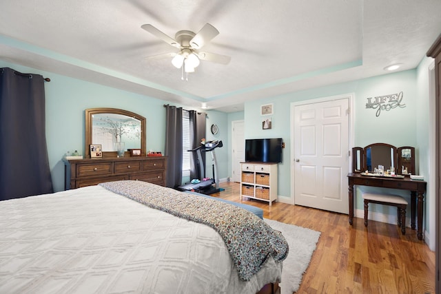 bedroom with baseboards, a ceiling fan, and light wood-type flooring