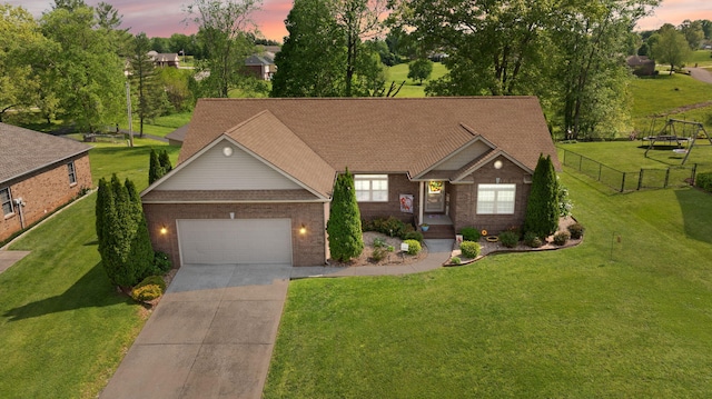 view of front of property with a front lawn, fence, brick siding, an attached garage, and driveway