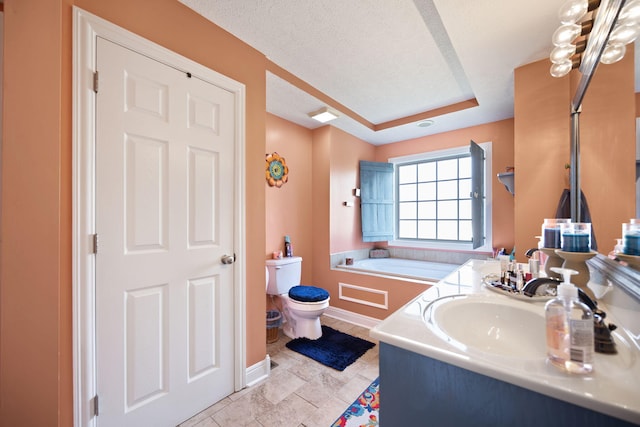 bathroom featuring vanity, baseboards, toilet, and a raised ceiling