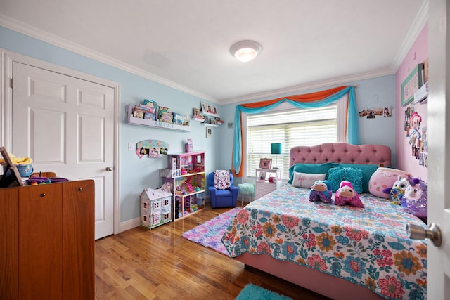 bedroom with crown molding, baseboards, and wood finished floors