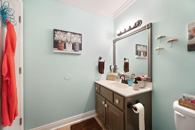 bathroom with vanity, ornamental molding, and toilet