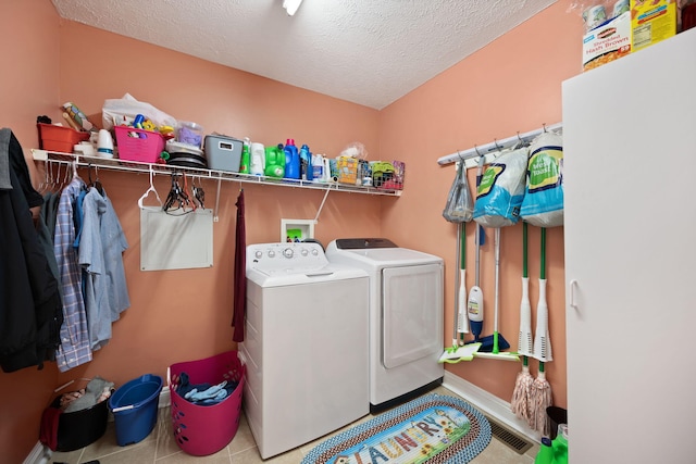 laundry area featuring laundry area, a textured ceiling, and washing machine and clothes dryer