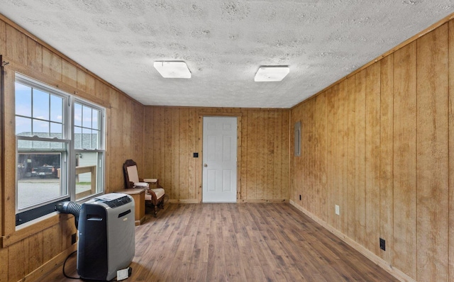 2555 Chrisman Ln, Danville, KY 40422 - unfurnished room featuring wood walls, a textured ceiling, hardwood / wood-style flooring, and baseboards